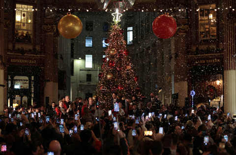 Pengunjung mengangkat perangkat seluler mereka untuk merekam lampu Natal yang dinyalakan di Pasar Leadenhall di London, Inggris, 13 November 2025. Foto: Corey Rudy/Reuters