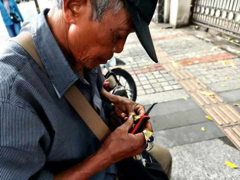 Penjual cincin batu akik, Manto (60) berada di Jalan Asia Afrika, Kota Bandung, Sabtu (15/11/2025).  Foto: Linda Lestari/kumparan