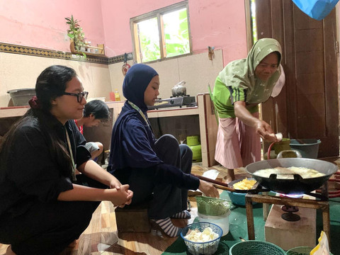 Saya dan teman saya mebantu menggoreng keripik singkong di dapur rumah (Foto: Dokumentasi Pribadi).