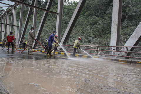 Petugas menyemprotkan air untuk membersihkan jalan yang terdampak abu vulkanik erupsi Gunung Semeru di Jembatan Curah Kobokan, Lumajang, Jawa Timur, Kamis (20/11/2025). Foto: Irfan Sumanjaya/ANTARA FOTO