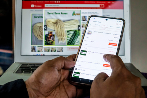 Pemilik Alfiber Serat Daun Nanas Subang Alan Sahroni memantau penjualan produk olahan serat limbah daun nanas di salah satu lokapasar (e-commerce). Foto: Abdan Syakura/ANTARA FOTO