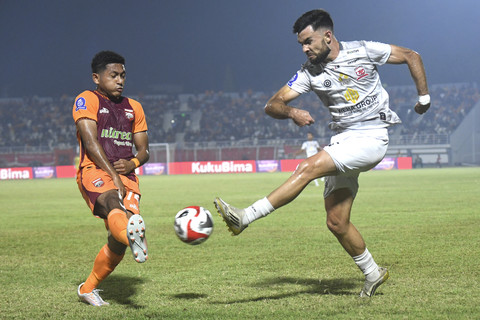 Pesepak bola Borneo FC Samarinda Muhammad Fajar Faturrahman (kiri) menahan bola dari tendangan pesepak bola Madura United Roger Bonet Badia (kanan) dalam lanjutan BRI Super League di Stadion Segiri Samarinda, Kalimantan Timur, Sabtu (22/11/2025). Foto: M Risyal Hidayat/ANTARA FOTO