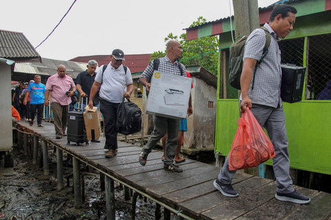 Sejumlah petugas Disdukcapil Medan berjalan menuju lokasi perekaman data kependudukan saat program jemput bola di Kampung Nelayan Seberang, Belawan. Foto: Yudi Manar/ ANTARA FOTO