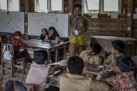 Guru Armani bercengkrama dengan siswa saat kegiatan belajar mengajar dimulai. Foto: Muhammad Bagus Khoirunas/ANTARA FOTO
