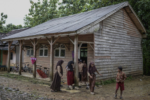 Siswa berjalan di depan bangunan yang menjadi ruang belajar di SD Negeri 2 Sorongan kelas jauh Batu Payung, Pandeglang, Banten. Foto: Muhammad Bagus Khoirunas/ANTARA FOTO