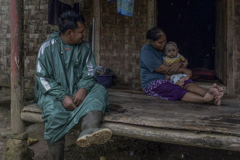 Guru Armani (kiri) berbincang dengan orang tua murid saat beristirahat menunggu hujan reda. Foto: Muhammad Bagus Khoirunas/ANTARA FOTO