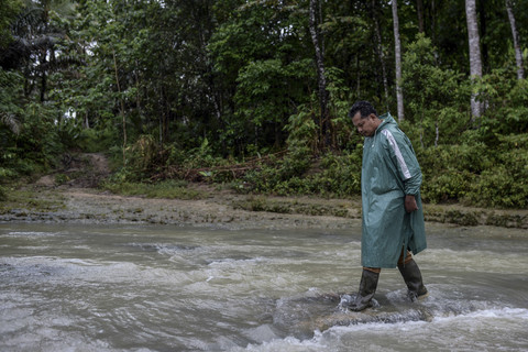 Guru Armani berjalan melintasi sungai Cisuakan menuju sekolah SD Negeri 2 Sorongan kelas jauh Batu Payung sepanjang tiga kilometer. Foto: Muhammad Bagus Khoirunas/ANTARA FOTO