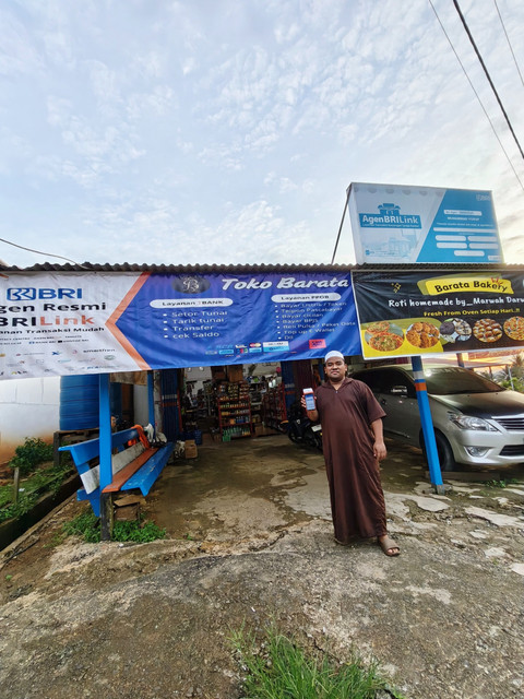 Muhammad Yusuf, pemilik Barata AgenBRILink di Desa Liangbunyu, Sebatik Barat, Kalimantan Utara, menunjukkan layanan digital BRI yang ia operasikan dari tokonya pada Sabtu, (29/11). Foto: dok. Istimewa