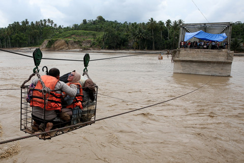 Warga menggunakan kabel baja yang  untuk menyeberangi Sungai Juli pascaputusnya Jembatan Juli di jalan lintas Bireuen - Takengon, Aceh, Selasa (2/12/2025). Foto: Irwansyah Putra/ANTARA FOTO