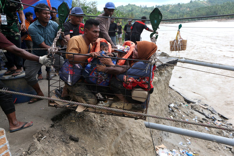 Warga menggunakan kabel baja yang  untuk menyeberangi Sungai Juli pascaputusnya Jembatan Juli di jalan lintas Bireuen - Takengon, Aceh, Selasa (2/12/2025). Foto: Irwansyah Putra/ANTARA FOTO