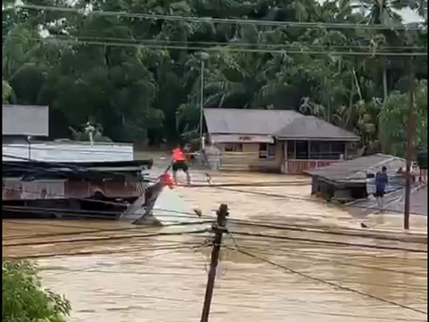Sertu Giman Syahputra, meniti kabel untuk mengevakuasi keluarga yang terjebak banjir di Aceh Tamiang Foto: Dok. Istimewa