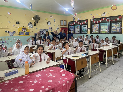 Tim KKN DTKI ITS menjelaskan cara membuat lilin aromaterapi di depan kelas kepada siswa SD Mojo VII Surabaya.