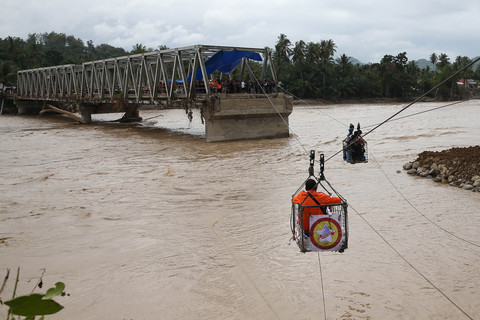 Warga menggunakan kabel baja yang  untuk menyeberangi Sungai Peusangan pascaputusnya jembatan Teupin Mane yang menghubungkan Kabupaten Bireuen dengan dataran tinggi Gayo di Juli, Bireuen, Aceh, Minggu (7/12/2025). Foto: Irwansyah Putra/ANTARA FOTO