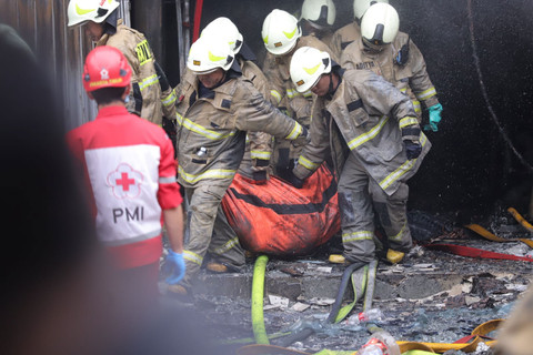 Petugas pemadam kebakaran membawa kantong jenazah dari dalam Gedung Terra Drone yang terbakar di Kemayoran, Jakarta Pusat, Selasa (9/12/2025). Foto: Jamal Ramadhan/kumparan