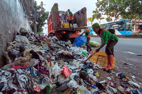Petugas Suku Dinas Lingkungan Hidup (Sudin LH) Kota Administrasi Jakarta Selatan mengangkut tumpukan sampah konveksi yang berada di trotoar kawasan Warung Buncit, Jakarta Selatan, Rabu (10/12/2025).   Foto: Jamal Ramadhan/kumparan