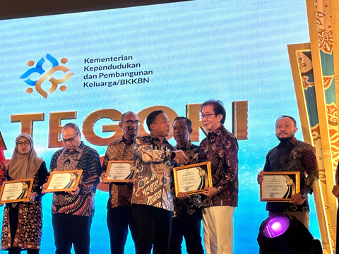 Irwan Hidayat menerima penghargaan langsung dari Menteri Kependudukan dan Pembangunan Keluarga, Wihaji. Foto: Wina R./kumparan