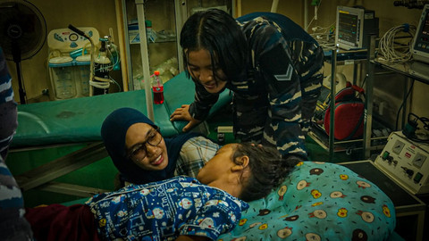 Anggota TNI menghibur anak korban bencana alam yang dievakuasi dari Dusun Kuala Pusung Kapal, Aceh Tamiang, yang alami patah tulang. Foto: Dok. TNI AL