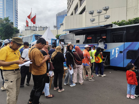 Warga di Car Free Day (CFD) Bundaran HI antre bayar pajak kendaraan di Samsat Keliling pada Minggu (14/12/2025). Foto: Luthfi Humam/kumparan