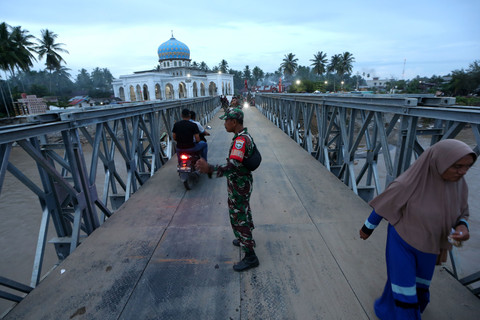 Warga melewati jembatan bailey yang menghubungkan Bireuen dengan Kabupaten Bener Meriah dan kabupaten lainnya saat uji coba di Juli, Bireuen, Aceh, Minggu (14/12/2025). Foto: Irwansyah Putra/ANTARA FOTO