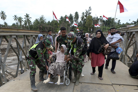 Prajurit TNI membantu warga saat melewati Jembatan Bailey Awe Geutah yang baru selesai dibangun setelah sebelumnya putus akibat bencana banjir bandang di Bireuen, Aceh, Kamis (18/12/2025). Foto: Irwansyah Putra/ANTARA FOTO