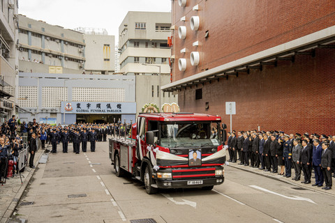 Sejumlah petugas kepolisian memberikan salam hormat saat pemakaman jenazah korban kebakaran Apartemen Wang Fuk Court di Hung Hom, Hong Kong, Jumat (19/12/2025). Foto: Leung Man Hei/AFP