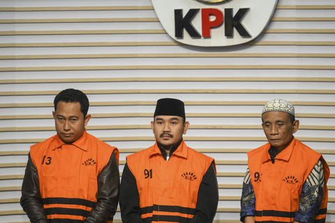 Bupati Bekasi Ade Kuswara Kunang (tengah) bersama ayahnya, H. M. Kunang (kanan), dan pihak swasta Sarjan mengenakan rompi tahanan dihadirkan saat konferensi pers usai terjaring operasi tangkap tangan di Gedung Merah Putih KPK, Jakarta, Sabtu (20/12/2025). Foto: Hafidz Mubarak A/ ANTARA FOTO