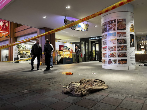 Petugas polisi berdiri di samping bekas darah setelah setelah seseorang melepaskan bom asap dan menyerang pejalan kaki di luar toko Eslite Spectrum Nanxi dekat Stasiun Zhongshan, Taiwan, Jumat (19/12/2025). Foto: Ann Wang/Reuters