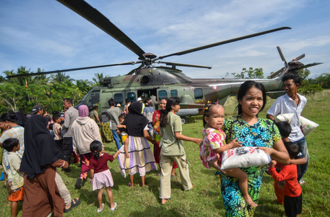 Warga membawa bantuan yang didistribusikan dari Helikopter Caracal Skadron Udara 8 Lanud Atang Sendjaja di Nagari Ranah Pasisie, Pasaman Barat, Sumatera Barat, Minggu (21/12/2025). Foto: Iggoy el Fitra/ANTARA FOTO