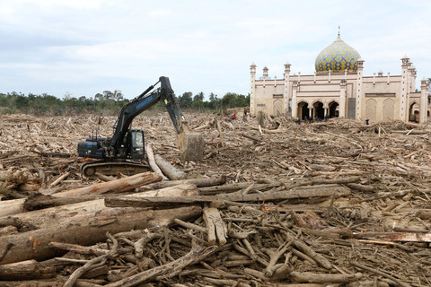 Petugas mengoperasikan alat berat untuk membersihkan gelondongan kayu di pesantren Islam Terpadu Darul Mukhlishin, Desa Tanjung Karang, Aceh Tamiang, Aceh, Minggu (21/12/2025). Foto: Irwansyah Putra/ANTARA FOTO