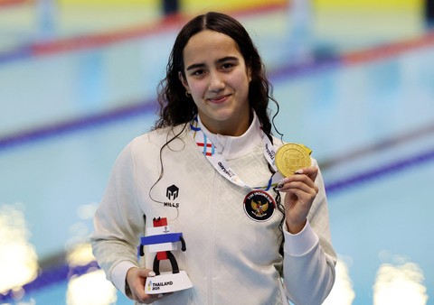 Perenang Indonesia Masniari Wolf memamerkan medali emas nomor 50 meter gaya punggung putri SEA Games 2025 di SAT Swimming Pool, Bang Kapi, Bangkok, Kamis (11/12/2025). Foto: Patipat Janthong/ REUTERS