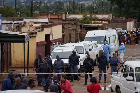 Polisi Afrika Selatan berkumpul di lokasi penembakan massal di kota Bekkersdal, barat daya Johannesburg, Afrika Selatan, Minggu (21/12/2025) waktu setempat. Foto: Alfonso Nqunjana/AP Photo