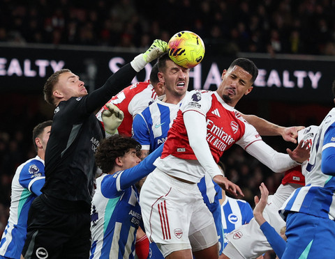 Bart Verbruggen dan Lewis Dunk dari Brighton & Hove Albion beraksi dengan William Saliba dari Arsenal pada pertandingan Liga Inggris antara Arsenal vs Brighton & Hove Albion di Stadion Emirates, London, Sabtu (27/12/2025). Foto: John Sibley/REUTERS