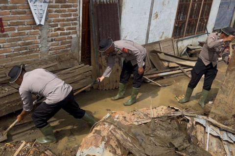 Personel Brimob membersihkan rumah warga di Agam, Sumatera Barat. Foto: Bakom RI