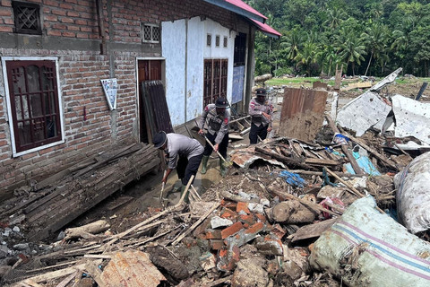 Personel Brimob membersihkan rumah warga di Agam, Sumatera Barat. Foto: Bakom RI