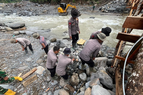 Personel TNI-Polri membangun jembatan darurat di Agam, Sumatera Barat. Foto: Bakom RI