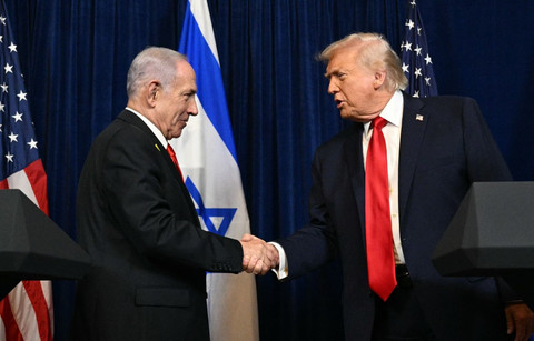 Presiden AS Donald Trump berjabat tangan dengan PM Israel Benjamin Netanyahu saat konferensi pers di klub Mar-a-Lago miliknya pada 29 Desember 2025 di Palm Beach, Florida. Foto: Joe Raedle/Getty Images/AFP
