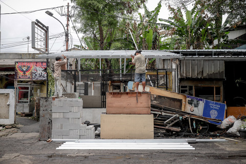 Dua pekerja melakukan perbaikan kios setelah terdampak kebakaran pascakericuhan di kawasan Kalibata, Jakarta Selatan, Sabtu (3/1/2026). Foto: Jamal Ramadhan/kumparan