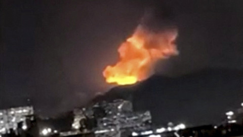 Sebuah kolom asap membubung tinggi selama serangkaian ledakan pada dini hari di Caracas, Venezuela, Sabtu (3/1/2026). Foto: Video obtained by Reuters/via REUTERS