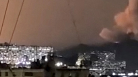 Sebuah kolom asap membubung tinggi selama serangkaian ledakan pada dini hari di Caracas, Venezuela, Sabtu (3/1/2026). Foto: Video obtained by Reuters/via REUTERS