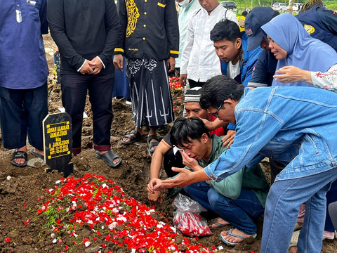 Khadafi menangis saat di Makam keluarganya yang meninggal di kontrakan di TPU Rorotan, Jakarta Utara, Jakarta Utara, Sabtu (3/1/2026). Foto: Rayyan/Kumparan