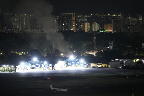 Asap membubung setelah ledakan dan pesawat terbang rendah saat serangan udara yang diduga dari Amerika Serikat di Pangkalan udara militer La Carlota, Caracas, Venezuela, Sabtu (3/1/2026). Foto: Matias Delacroix/AP Photo