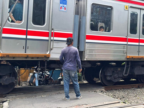 Indra (55), penjaga palang kereta api di perlintasan sekitar Stasiun Tebet, Jakarta Selatan, Minggu (4/1/2026). Foto: Amira Nada/kumparan