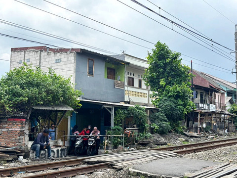 Sejumlah pengendara motor menunggu palang kereta api di pinggir perlintasan kereta sekitar Stasiun Tebet, Jakarta Selatan, Minggu (4/1/2026). Foto: Amira Nada/kumparan