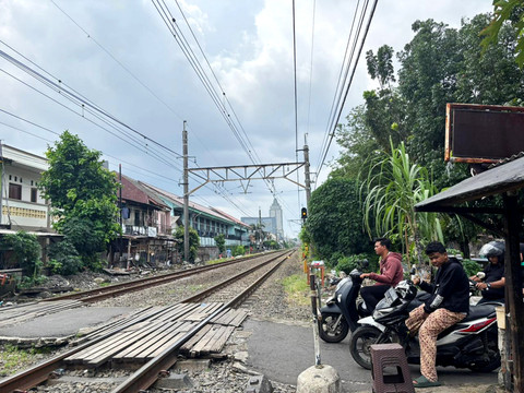 Sejumlah pengendara motor menunggu palang kereta api di pinggir perlintasan kereta sekitar Stasiun Tebet, Jakarta Selatan, Minggu (4/1/2026). Foto: Amira Nada/kumparan