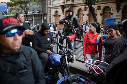 Anggota kelompok milisi yang dikenal sebagai "Colectivos" membawa senjata ikut serta dalam pawai yang menyerukan pembebasan Presiden Venezuela Nicolas Maduro. Foto: REUTERS/Gaby Oraa