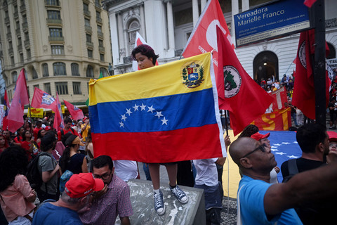 Seorang wanita menunjukkan bendera Venezuela saat ia ikut serta dalam demonstrasi mendukung Presiden Venezuela Nicolas Maduro di alun-alun Cinelandia di Rio de Janeiro, Brasil, Senin (5/1/2026). Foto: Mauro Pimentel/AFP