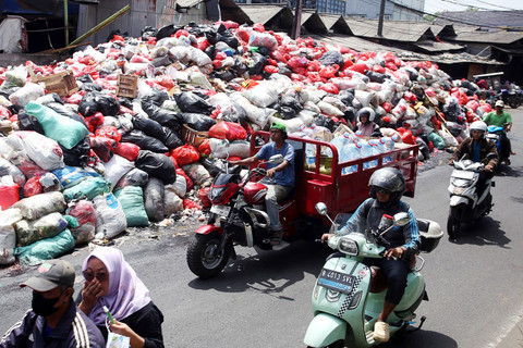 Sejumlah pengendara melintas di samping gunungan sampah yang ada di Jalan Raya Otista, Cimanggis, Tangerang Selatan, Banten, Selasa (6/1/2026). Foto: Muhammad Iqbal/ANTARA FOTO