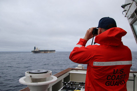 Seorang pejabat Penjaga Pantai Amerika Serikat melihat melalui teropong ke arah kapal Marinera (sebelumnya Bella 1) dalam gambar selebaran (handout) yang dirilis pada 7 Januari 2026.  Foto: US EUROPEAN COMMAND via X/Handout via REUTERS