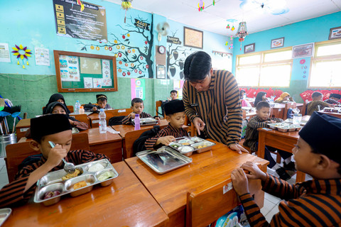 Petugas menjelaskan kandungan gizi kepada siswa saat mendistribusikan paket makanan menu kuliner nusantara untuk program Makan Bergizi Gratis (MBG) di SD Negeri Tanjunganom 3, Nganjuk, Jawa Timur, Kamis (8/1/2026). Foto: Muhammad Mada/ANTARA FOTO