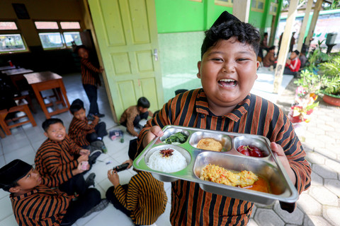 Siswa menunjukan paket makanan menu kuliner nusantara untuk program Makan Bergizi Gratis (MBG) di SD Negeri Tanjunganom 3, Nganjuk, Jawa Timur, Kamis (8/1/2026). Foto: Muhammad Mada/ANTARA FOTO
